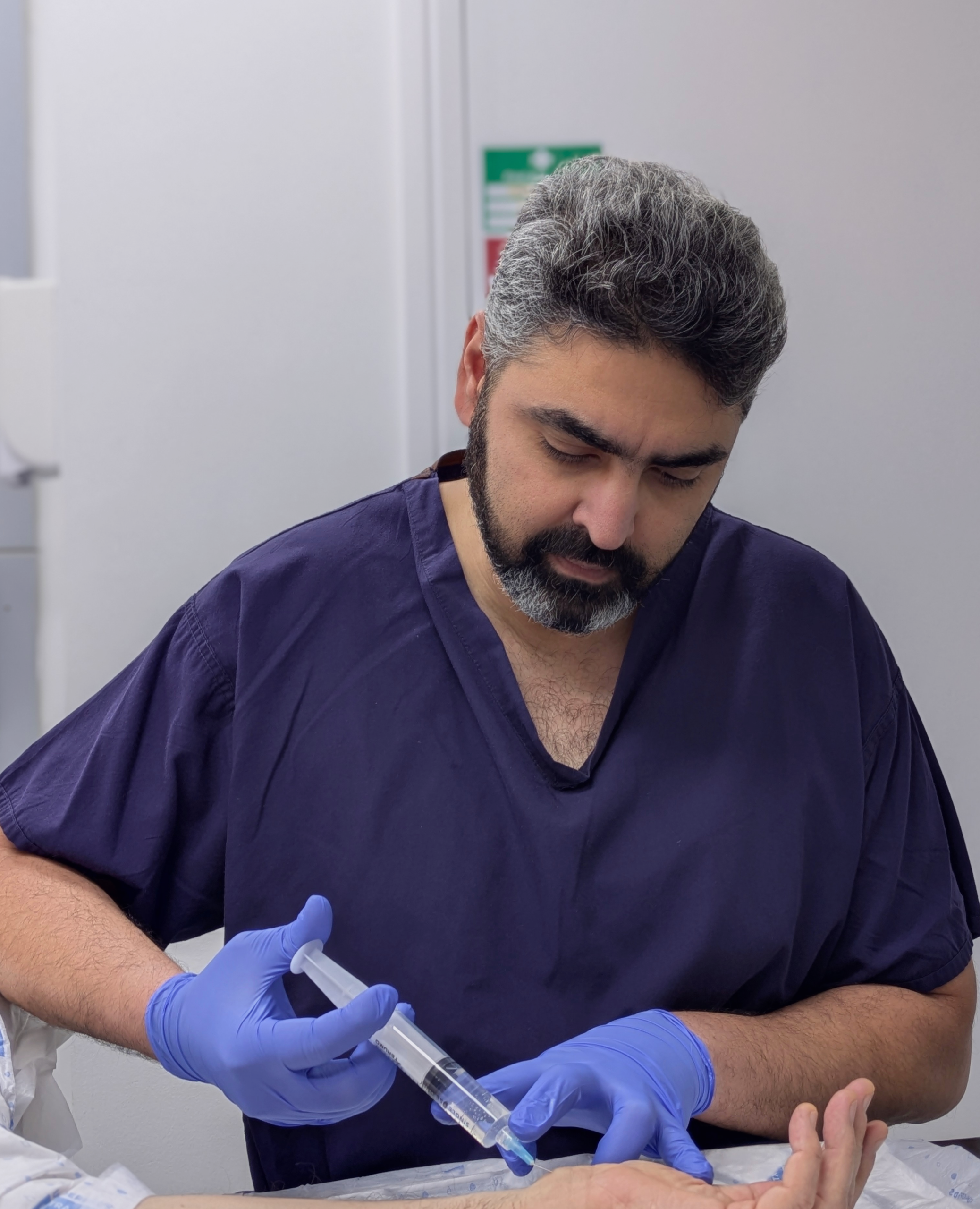 Orthopaedic hand surgery specialist Abhinav Gulihar performing hand treatment on a patient